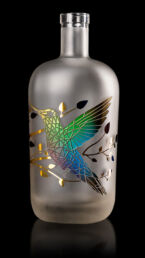 Gravure d'un colibri sur une bouteille satinée et décorée d'un marquage à chaud, multi couleurs fondues. Réalisation MSV.